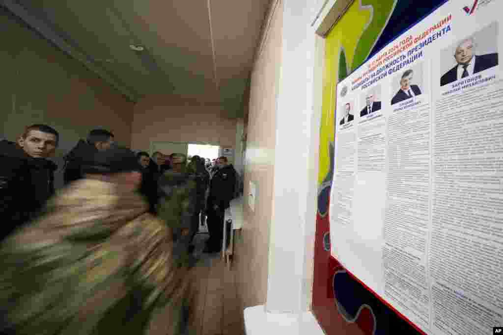 Російські військовослужбовці стоять у черзі, щоб проголосувати на виборчій дільниці під час президентських виборів у Санкт-Петербурзі, Росія, у п’ятницю, 15 березня 2024 р. Голосування у Росії триватиме три дні до неділі, 17-го березня. (Фото: AP Photo/Dmitri Lovetsky)