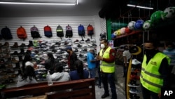 Funcionarios municipales de salud pública en Ecatepec, estado de México, informan a empleados y clientes de una zapatería que el negocio debe cerrar a las 5pm de acuerdo a nuevas restricciones por COVID.
