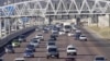 Cars stream underneath a gantry on a road to Pretoria, South Africa, May 4, 2012. 