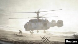 FILE - Servicemen take part in the joint war games Zapad-2013 (West-2013), at the Khmelevka range on Russia's Baltic Sea in the Kaliningrad Region, Sept. 26, 2013.