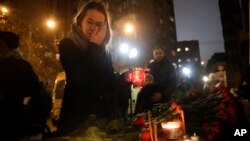 Une femme dépose une bougie à Moscou en Russie, le 25 décembre 2016.