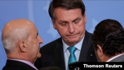 El presidente de Brasil, Jair Bolsonaro, mira en un teléfono móvil del Jefe de la Secretaría de Gobierno de la Presidencia, el jueves 1 de octubre de 2020. 