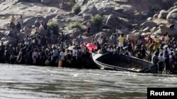 Orang-orang Etiopia yang melarikan diri dari konflik di Tigray bersiap menyeberang Sungai Setit di perbatasan Sudan-Etiopia di Desa Hamdait, di negara bagian Kassala, Sabtu, 14 November 2020. 