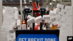 Premijer Velike Britanije Boris Džonson vozi bager sa natpisom "Obavimo Bregzit" kroz simboličan zid tokom svoje predizborne kampanje.