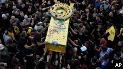 Konbatan Hezbollah yo transpote sekey youn nan kanmarad yo ki mouri apre bipe yo eksploze nan Beirout, Liban, 18 Sept. 2024.