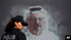 Polisi Turki berjalan di depan gambar Jamal Khasoggi, dekat kedutaan Arab Saudi di Istanbul, menjelang peringatan setahun meninggalnya jurnalis Washington Post itu, Oktober 2018. (Foto: dok).