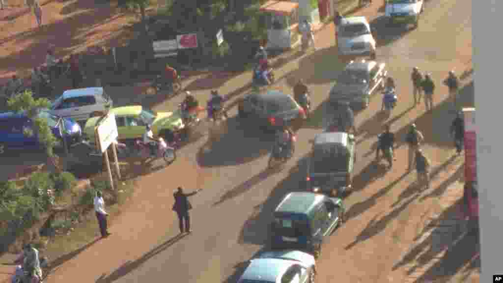Mutane su na gudu daga hotel din Radisson Blu Hotel na Bamako, Mali, Jumma'a, Nov. 20, 2015.