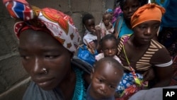 Raseljene žene i deca čekaju na pomoć u Pembi u Mozambiku, nakon što su pobegle od napada u Palmi, u severnom Mozambiku, 19. aprila 2021.