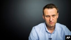 In this photo provided by Alexei Navalny's campaign, Russian opposition leader Alexei Navalny records a video for his YouTube channel in his office in Moscow, Russia, July 7, 2017.