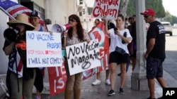 Anti-vaccine mandate protesters rally outside the garage doors of the Los Angeles Unified School District, LAUSD headquarters in Los Angeles Thursday Sept. 9, 2021. (AP Photo/Damian Dovarganes) 
