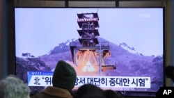 Ljudi gledaju preko televizije fotografi zemaljskog testa motora u Severnoj Koreji, na železničkoj stanici u Seulu, Južna Koreja, 9. decembra 2019.
