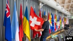 Daniel Egger coloca la bandera de Suiza durante los preparativos finales de la Cumbre sobre la paz en Ucrania, en Stansstad, al sur de Lucerna, el 13 de junio de 2024.