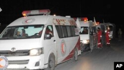 A photo released by the Syrian official news agency SANA, shows members of the Syrian Arab Red Crescent gathering near their ambulances during an evacuation of sick and wounded people from eastern Ghouta, near Damascus, Syria, Dec. 28, 2017. 