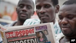 Quelques personnes lisent l'exemplaire d'un journal à Kampala,, 25 février 2014.
