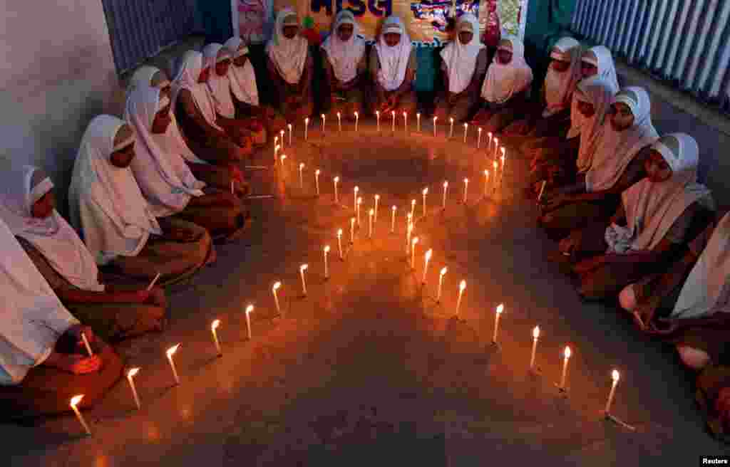Les filles dans une école en Inde allument des bougies lors d'une campagne de sensibilisation au VIH / SIDA à Ahmedabad, le 30 novembre 2016.