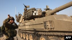 Ізраїльський солдат вказує напрям руху для самохідної гаубиці в Ашкелоні, 8 жовтня 2023. Photo by GIL COHEN-MAGEN/ AFP