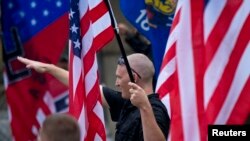 FILE - A member of a white supremacy group gives a fascist salute during a gathering in West Allis, Wisconsin, Sept. 3, 2011.