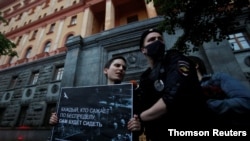 A Russian police officer detains a protester taking part in a picket in support of journalist Svetlana Prokopyeva, in Moscow, Russia, July 3, 2020.