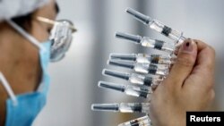 Seorang petugas tengah melakukan pemeriksaan kualitas di fasilitas pengemasan pembuat vaksin China Sinovac Biotech, pengembang vaksin eksperimental untuk Covid-19, saat berlangsungnya tur untuk awak media di Beijing, China, 24 September 2020.