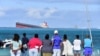 Des passants regardent le vraquier MV Wakashio qui s'était échoué près du parc marin de Blue Bay, dans le sud-est de l'île Maurice, le 6 août 2020. (Photo: Dev Ramkhelawon / L'Express Maurice / AFP)