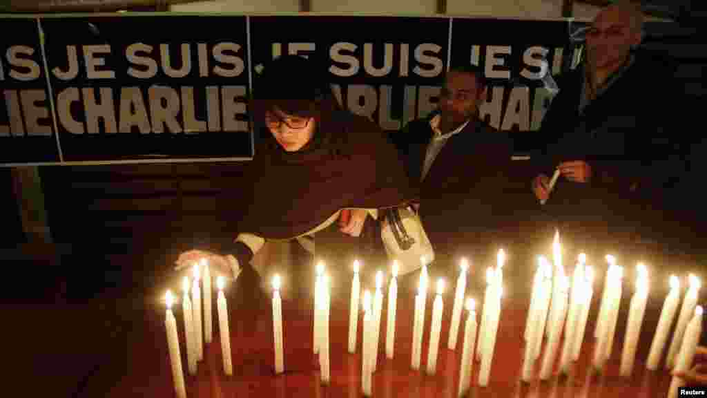 Des bougies sont placées devant une bannière mentionnant "Je suis Charlie" à l'ambassade française à Hanoi, au Vietnam, le 8 janvier 2015.