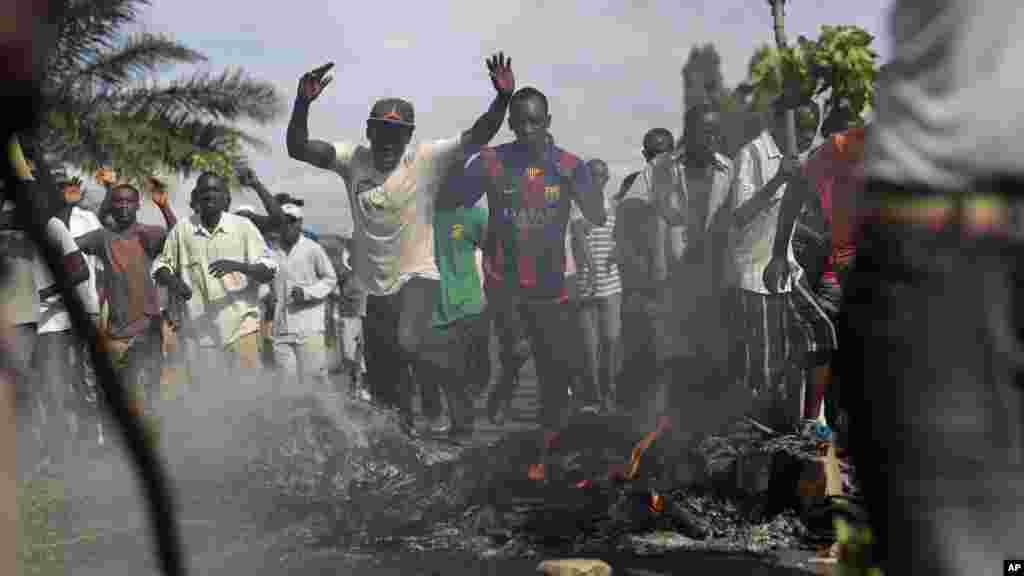 Scandant «passons !», des manifestant forcent une barricade dans le quartier de Musaga de Bujumbura, au Burundi, le lundi 4 mai 2015.