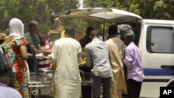 Local officials remove the body of a victim from the back of a bus, in front of Aminu Kano teaching hospital in Nigeria's northern city of Kano, April 29, 2012.