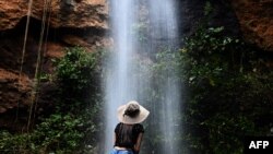 Un turista disfruta bajo una cascada durante la reapertura gradual del turismo en El Salvador, después de la cuarentena obligatoria para prevenir nuevas infecciones de COVID-19, en San Julián, Sonsonate, el 30 de septiembre de 2020.