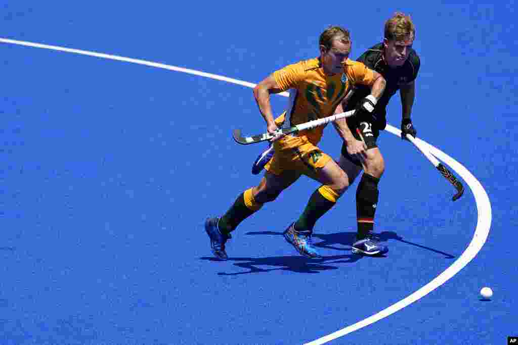 South Africa's Nicholas Balfour Spooner (24) and Germany's Niklas Bosserhoff (26) chase the ball during a men's field hockey match at the 2020 Summer Olympics, Thursday, July 29, 2021, in Tokyo, Japan. (AP Photo/John Minchillo)