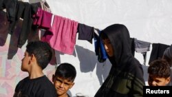 Palestinos desplazados que huyeron de sus casas debido a los ataques israelíes se refugian en un campamento cerca de la frontera con Egipto, en Rafah, el 11 de diciembre.