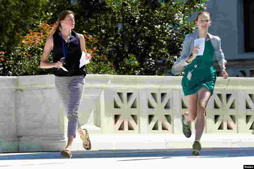 News assistants run out after the U.S. Supreme Court granted parts of the Trump administration's emergency request to put his travel ban into effect immediately while the legal battle continues, in Washington, D.C.