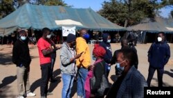 FILE - People queue to recieve COVID-19 vaccinations at a clinic in Harare, Zimbabwe, July 8, 2021.