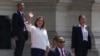 Rodeada por seguridad, la presidenta peruana Dina Boluarte saluda a la prensa afuera del palacio de gobierno cuando el primer ministro Alberto Otarola sale de Lima, Perú, el martes 10 de enero de 2023.