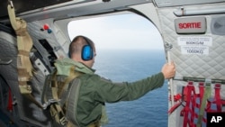 Seorang kru dari bagian Komunikasi dan Audio Visual Tentara Angkatan Darat Perancis (ECPAD) melakukan pencarian puing-puing pesawat MH370 yang hilang perairan La Reunion, Kepulauan Perancis, 7 Agustus 2015. (Foto: dok).
