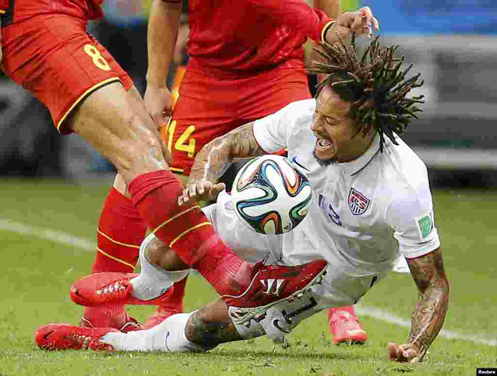 Belgium's Marouane Fellaini kicks the ball as Jermaine Jones of the U.S. defends during their game at the Fonte Nova arena in Salvador, July 1, 2014.