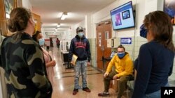 Estudiantes y personal docente de la Escuela Secundaria Comunitaria West Brooklyn, en Nueva York, conversan tras enterarse de que la escuela cerrará por tercera vez este año a causa del coronavirus, el 18 de noviembre de 2020.