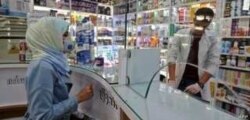 FILE - People wearing protective masks shop at a pharmacy in the Iranian capital Tehran, Feb. 24, 2020.