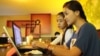 FILE PHOTO- University students from the Royal University of Phnom Penh check the Internet in a coffee shop along the city's Russian Federation Boulevard, June 13, 2014. (Suy Heimkhemra/VOA Khmer) 