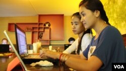 University students from the Royal University of Phnom Penh browsing the Internet at a coffee shop along Phnom Penh's Russian Federation Boulevard, June 13, 2014. (Photo: Suy Heimkhemra/VOA Khmer)