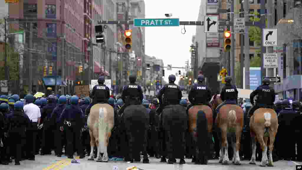 Polisi berusaha menghalangi demonstran yang memblokir jalan Pratt setelah berbaris menuju balai kota untuk Freddie Gray di Baltimore (25/4). (AP/Alex Brandon)