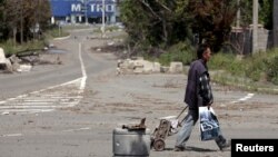 A man with a cart walks in a street in rebel-controlled Donetsk, Ukraine, July 18, 2015.