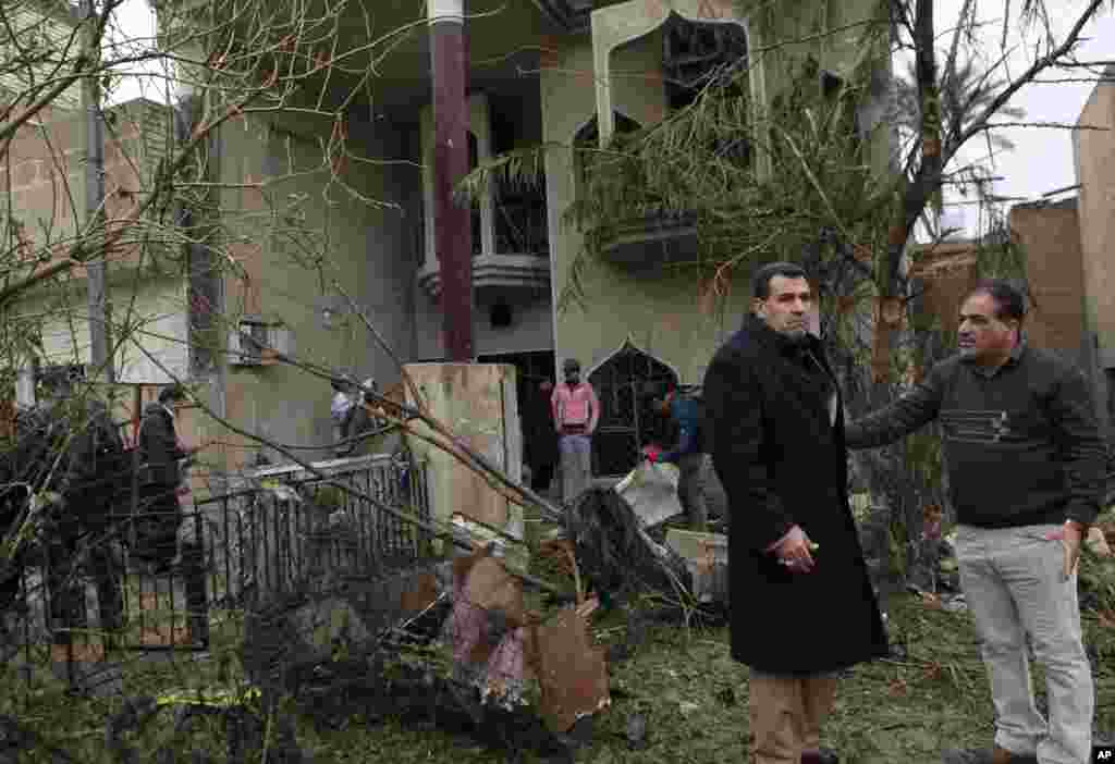Civilians inspect their damaged house after a car bombing in the Hurriyah neighborhood of northern Baghdad, Feb. 3, 2014.