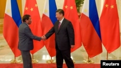 Chinese President Xi Jinping (R) shakes hands with Philippines President Rodrigo Duterte prior to their bilateral meeting during the Belt and Road Forum, at the Great Hall of the People in Beijing, China, May 15, 2017