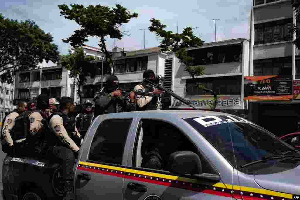 Comandos llega a una avenida de Caracas durante enfrentamientos. Juan Guaidó, considerado presidente interino por decenas de países, aseguró que las bandas fueron armadas años atrás por el Gobierno. Junio, 8 2021. Foto: Yuri Cortez - AFP.