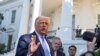 President Donald Trump, accompanied by White House Chief of Staff Mark Meadows, second from left, speaks with reporters on the South Lawn of the White House, in Washington, July 29, 2020.
