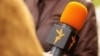 RFE/RL's Russian Service journalist with microphone during an interview undated