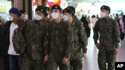 Soldados surcoreanos con mascarilla para protegerse del coronavirus abordan un tren en Seúl, el 3 de noviembre de 2020.