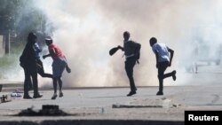 Waandamanaji wakikimbia huku mabomu ya machozi yakirushwa wakati wa mgomo unaoendelea wa wahudumu wa teksi dhidi ya mamlaka ya trafiki mjini Cape Town, Afrika Kusini, Agosti 7, 2023 REUTERS.
