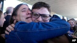 Un argentino que no pudo salir por días de Israel tras el ataque de Hamás sonríe al abrazarse a un familiar en el aeropuerto de Buenos Aires, este domingo.