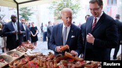 El vicepresidente Joe Biden comparte con el primer ministro, Aleksandar Vucic, en un mercado tradicional de Belgrado.